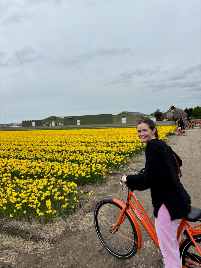 Smiling in front of a field of yellow flowers in Amsterdam, 2025. 