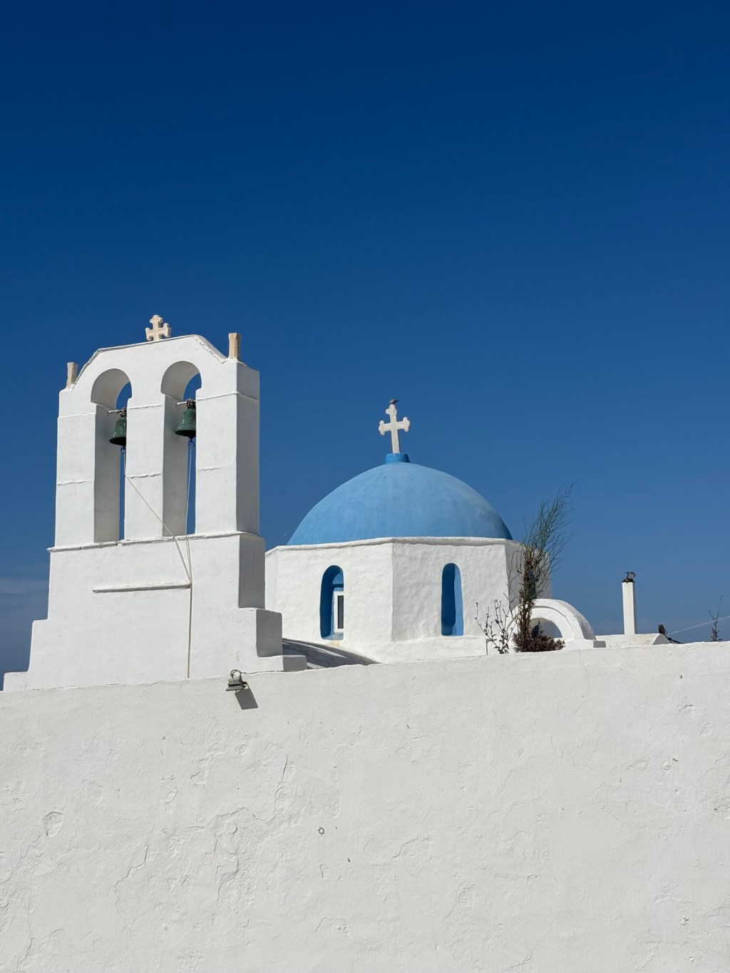 Blue-domed Greek Orthodox church against a deep blue sky